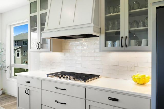 4737 130th Ln NE, Blaine, MN 55449 - kitchen featuring stainless steel gas cooktop, premium range hood, light countertops, and backsplash