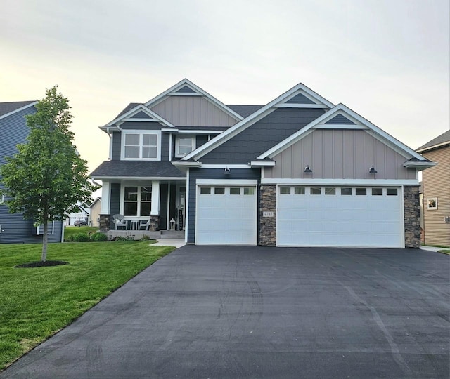 4737 130th Ln NE, Blaine, MN 55449 - craftsman-style home with board and batten siding, driveway, a front yard, stone siding, and a porch