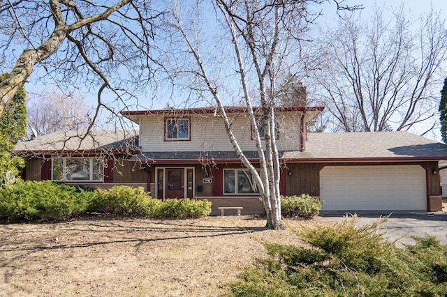 7740 Arlington Ave N, Brooklyn Park, MN 55443 - traditional-style house featuring a chimney, aphalt driveway, and a garage