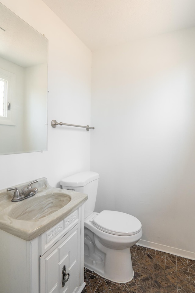 7740 Arlington Ave N, Brooklyn Park, MN 55443 - bathroom with baseboards, toilet, and vanity