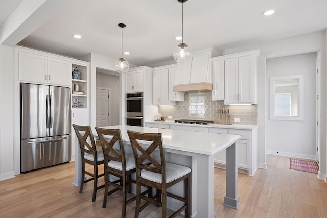 kitchen with light wood finished floors, light countertops, open shelves, and stainless steel appliances