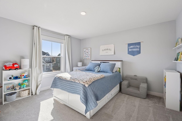 bedroom with baseboards and light carpet