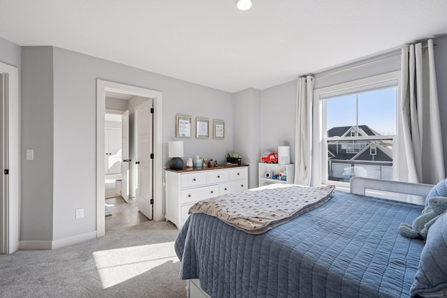 bedroom with baseboards and light colored carpet