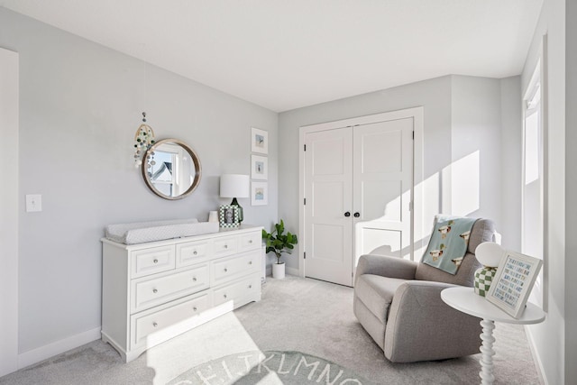 sitting room with baseboards and light carpet