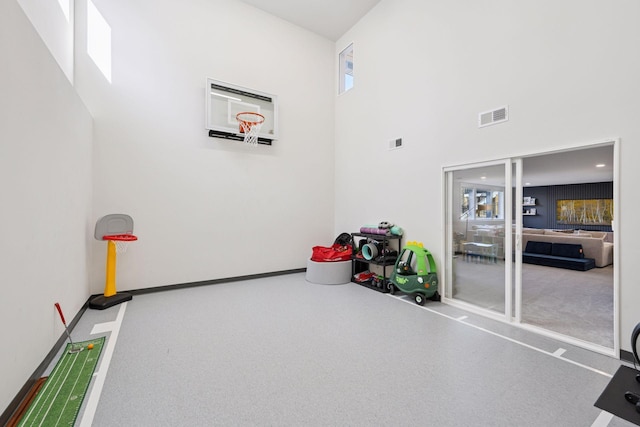 playroom featuring visible vents, a high ceiling, and baseboards