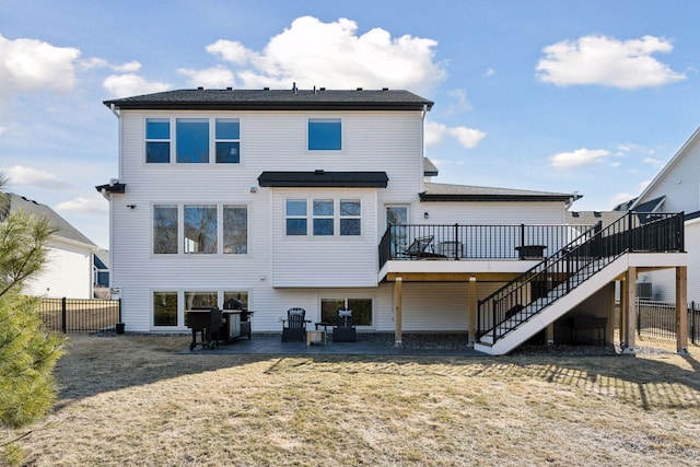 back of property with a lawn, stairway, a patio area, fence, and a deck