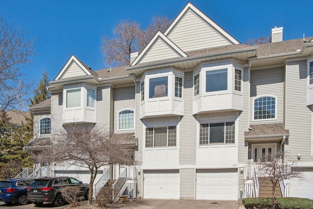 907 Fairfield Way, Minnetonka, MN 55305 - townhome / multi-family property featuring a garage, driveway, a shingled roof, and a chimney