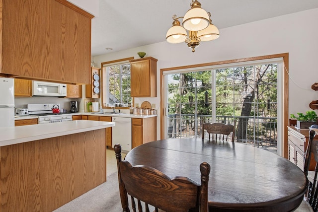 907 Fairfield Way, Minnetonka, MN 55305 - kitchen featuring white appliances, light countertops, light carpet, hanging light fixtures, and brown cabinets