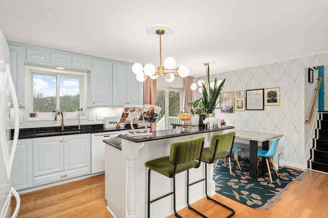1602 River St, Monticello, MN 55362 - kitchen featuring a sink, wallpapered walls, white appliances, light wood finished floors, and plenty of natural light