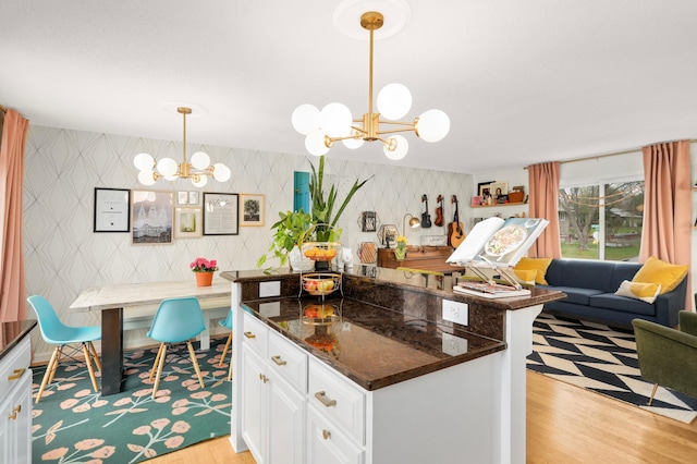 1602 River St, Monticello, MN 55362 - kitchen with a chandelier, wallpapered walls, light wood finished floors, white cabinets, and open floor plan