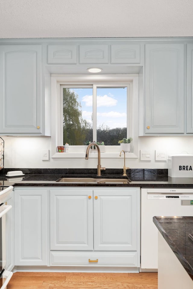 1602 River St, Monticello, MN 55362 - kitchen featuring a sink, white appliances, dark stone countertops, and white cabinetry