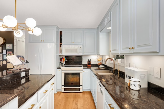 1602 River St, Monticello, MN 55362 - kitchen with white appliances, a sink, dark stone counters, a chandelier, and pendant lighting