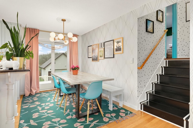 1602 River St, Monticello, MN 55362 - dining area featuring a chandelier, wallpapered walls, stairway, wood finished floors, and baseboards