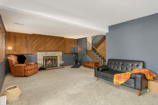 2628 Sumac Ct, White Bear Lake, MN 55110 - carpeted living room with wooden walls, stairs, beamed ceiling, and a brick fireplace