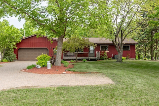 ranch-style home featuring decorative driveway, a front lawn, a garage, and central AC