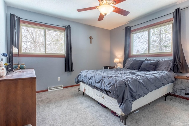 carpeted bedroom featuring multiple windows, baseboards, and ceiling fan
