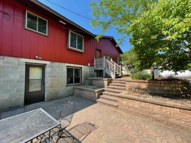 rear view of property with a patio area and board and batten siding