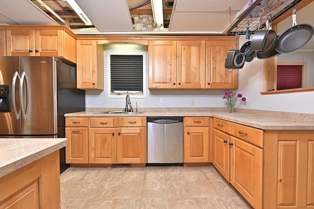 kitchen with stainless steel appliances, a sink, and light countertops