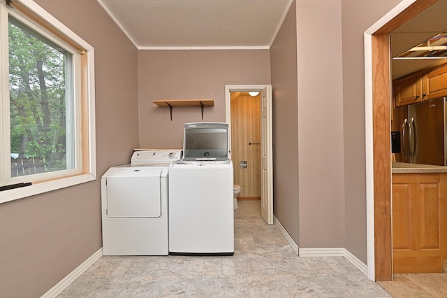 washroom featuring washer and dryer, crown molding, and baseboards