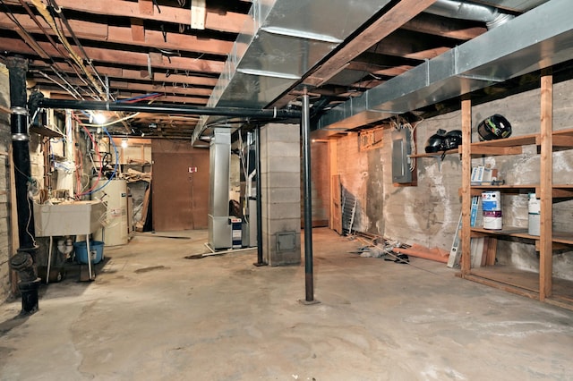 unfinished below grade area with water heater, electric panel, heating unit, and a sink