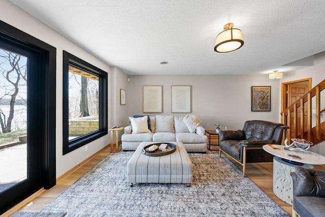 living room with a textured ceiling and stairway