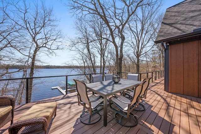 wooden deck with a water view and outdoor dining space