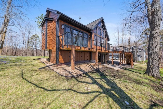 back of property with a lawn, a wooden deck, and stairs