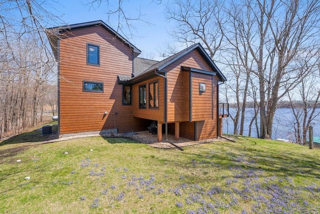 rear view of house with a yard and a water view