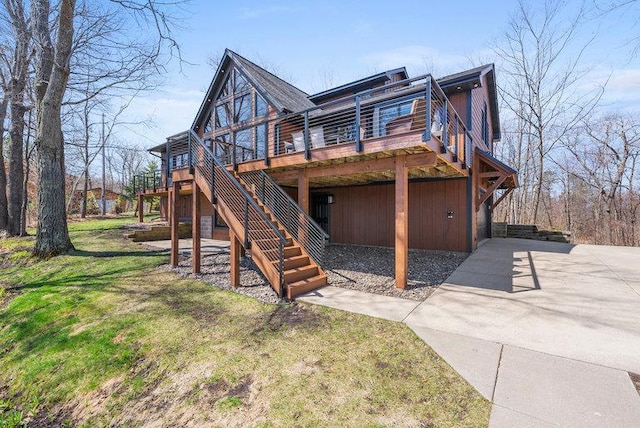 rear view of house with stairs, a wooden deck, and a yard