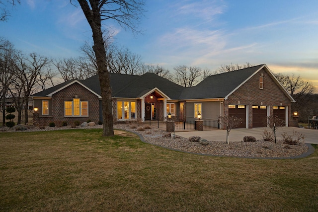 2834 12th Ave NW, Austin, MN 55912 - view of front of house with concrete driveway, a lawn, brick siding, and an attached garage