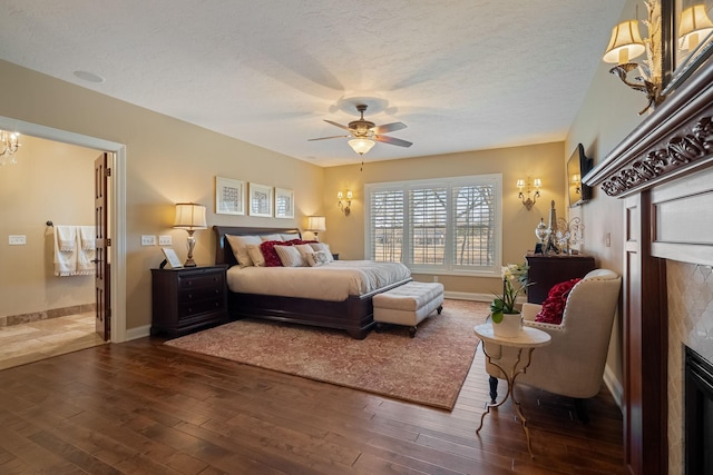 2834 12th Ave NW, Austin, MN 55912 - bedroom with a fireplace, dark wood-style floors, a textured ceiling, baseboards, and a chandelier