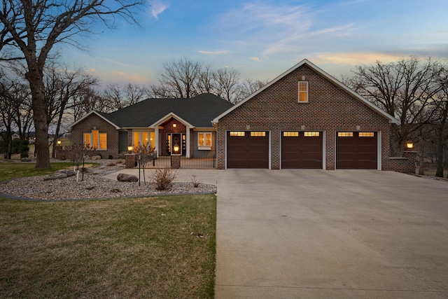 2834 12th Ave NW, Austin, MN 55912 - traditional-style home with driveway, a garage, brick siding, and a yard