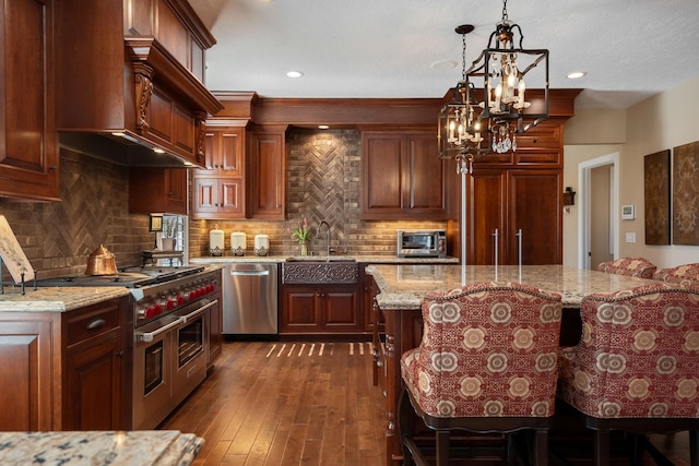2834 12th Ave NW, Austin, MN 55912 - kitchen featuring appliances with stainless steel finishes, a sink, a chandelier, dark wood-type flooring, and light stone countertops