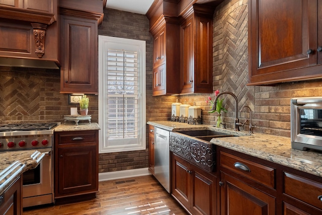 2834 12th Ave NW, Austin, MN 55912 - kitchen with appliances with stainless steel finishes, a sink, baseboards, tasteful backsplash, and light stone counters