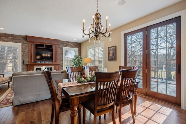 2834 12th Ave NW, Austin, MN 55912 - dining room with a chandelier, light wood-style floors, and brick wall