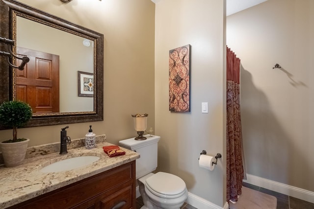 2834 12th Ave NW, Austin, MN 55912 - bathroom with toilet, baseboards, vanity, and tile patterned floors