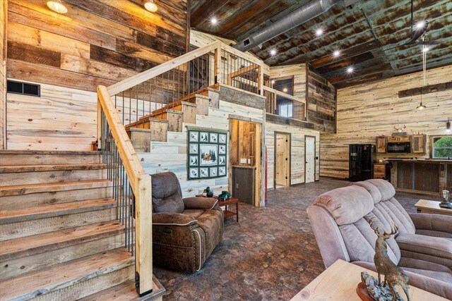 16688 248th St, Long Prairie, MN 56347 - living area featuring wood walls, a towering ceiling, and stairway