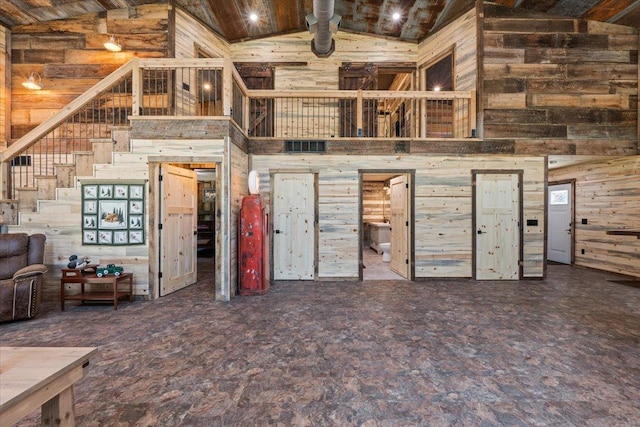 16688 248th St, Long Prairie, MN 56347 - unfurnished living room with wood walls, high vaulted ceiling, and stairway