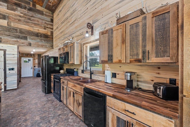 16688 248th St, Long Prairie, MN 56347 - kitchen with black appliances, a high ceiling, wood walls, a sink, and wooden counters