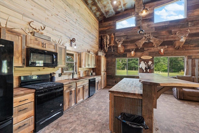 16688 248th St, Long Prairie, MN 56347 - kitchen with high vaulted ceiling, butcher block counters, black appliances, a sink, and wooden walls
