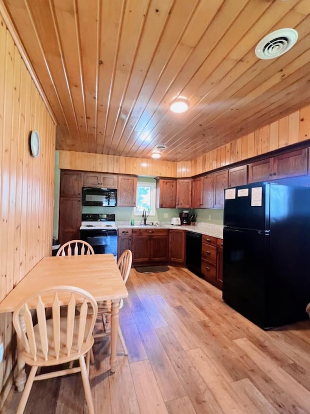 35629 Rush Lake Loop Unit 32, Rush Lake Twp, MN 56571 - kitchen featuring light wood-style floors, wooden walls, light countertops, wooden ceiling, and black appliances