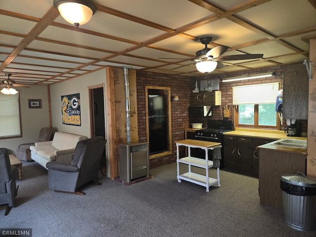 2857 281st Ave, Sterling Twp, WI 54024 - kitchen featuring black gas range, ceiling fan, dark carpet, brick wall, and fridge