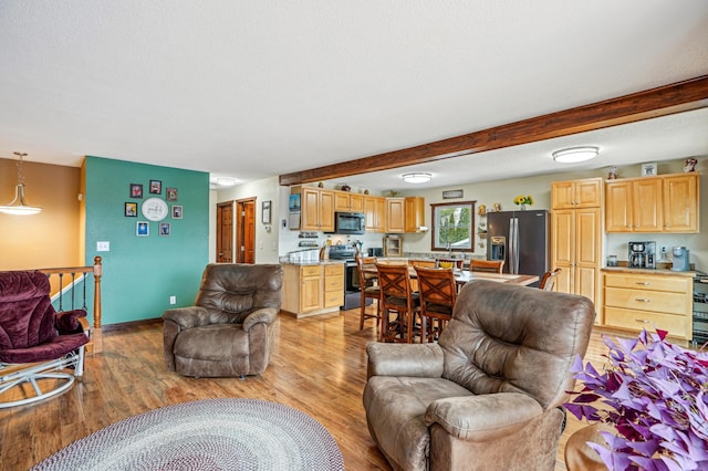 living room with baseboards, beamed ceiling, and light wood-type flooring