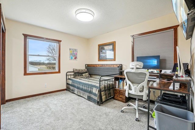 carpeted office space featuring baseboards and a textured ceiling