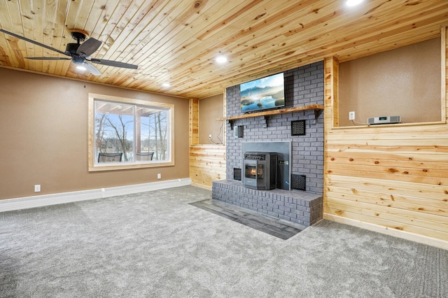 unfurnished living room with a ceiling fan, carpet flooring, wood ceiling, and baseboards