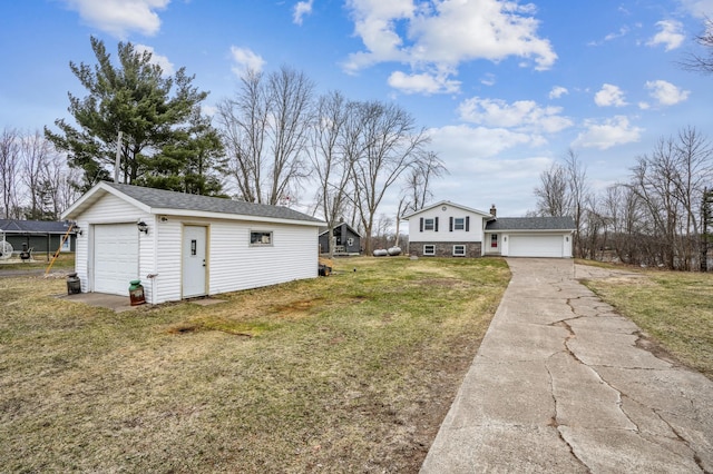 view of side of home with a yard, an outdoor structure, and a garage