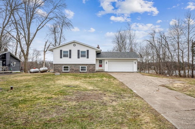 tri-level home featuring a front lawn, driveway, brick siding, and an attached garage