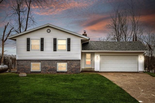 split level home featuring concrete driveway, a front yard, an attached garage, and a chimney