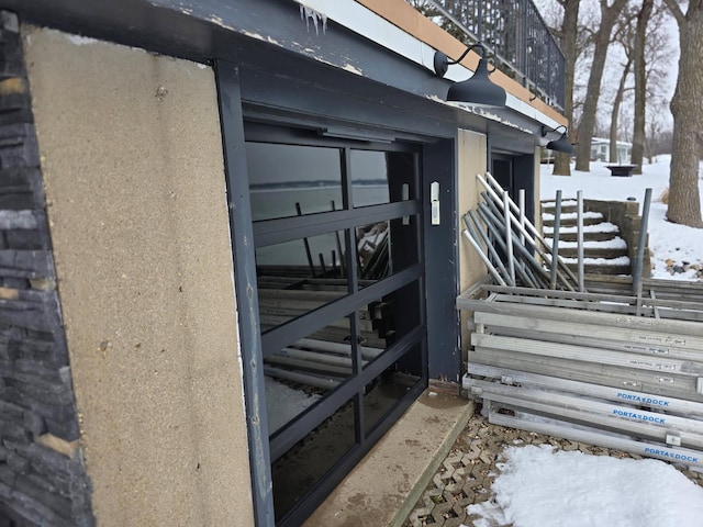 snow covered property entrance featuring stucco siding