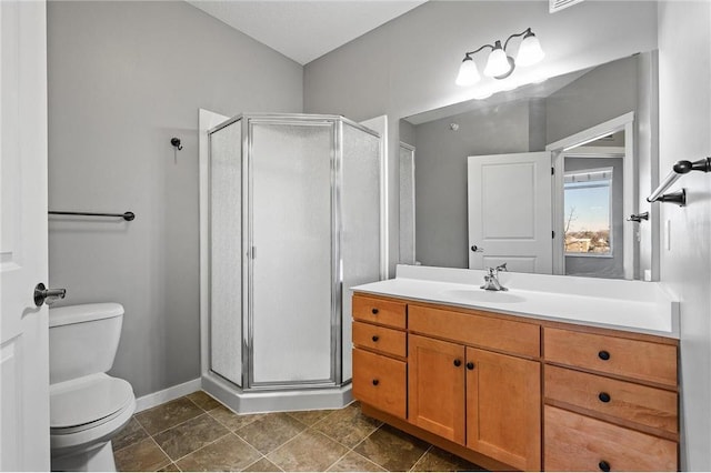 full bathroom featuring toilet, a stall shower, baseboards, and vanity